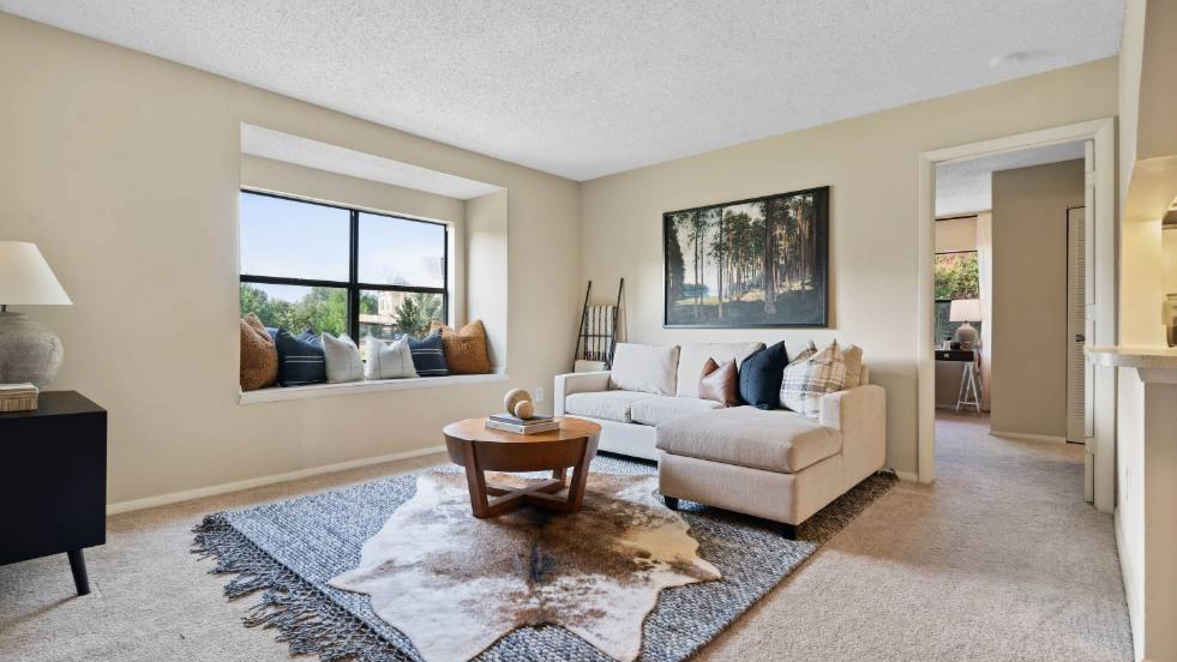 A cozy living room with a comfortable couch, a stylish coffee table, and a large window offering natural light at Hawthorne at Southside
